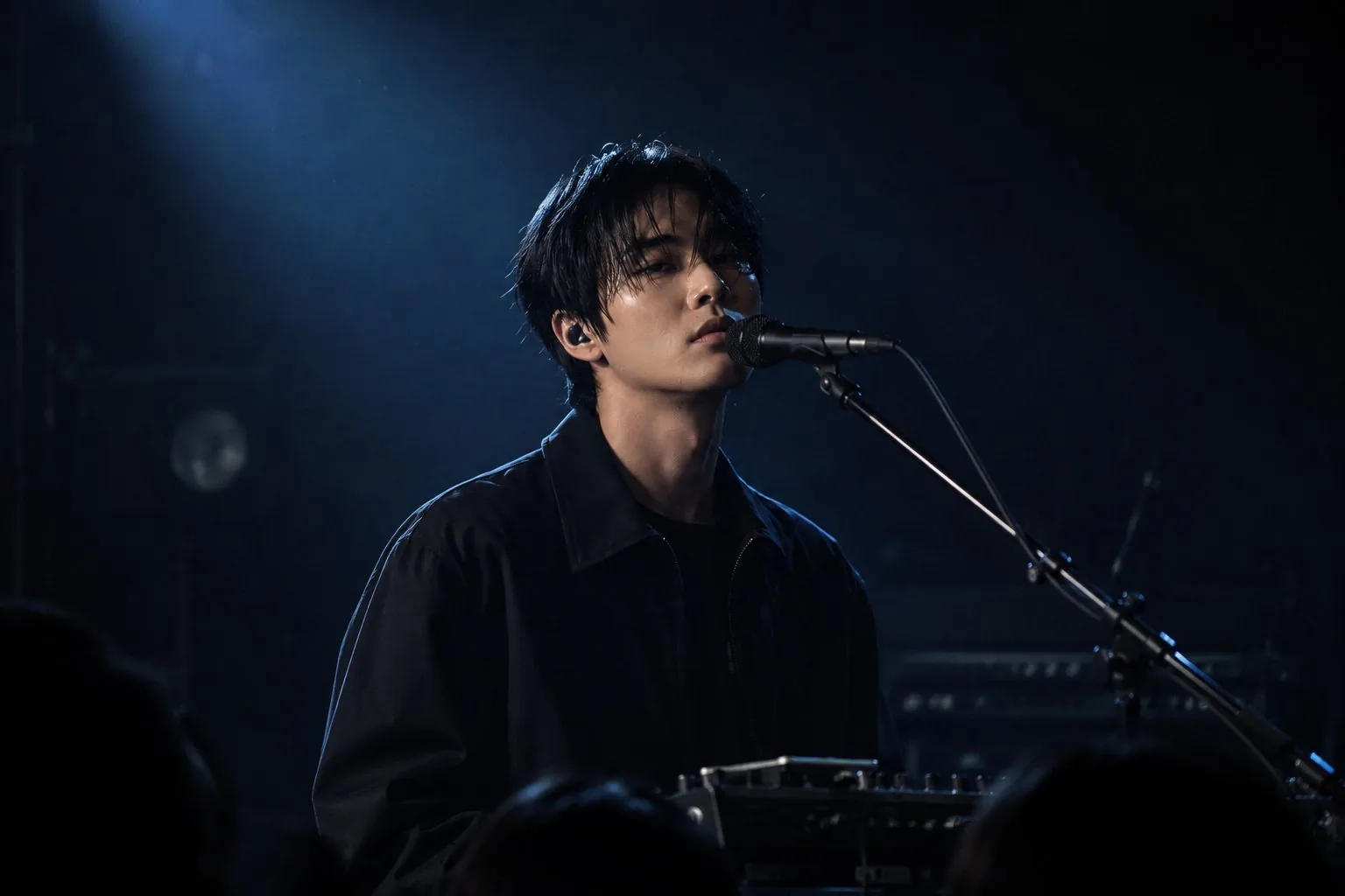 무대 조명 아래에서 마이크를 잡고 있는 NOIR WAVE의 라이브 공연 사진